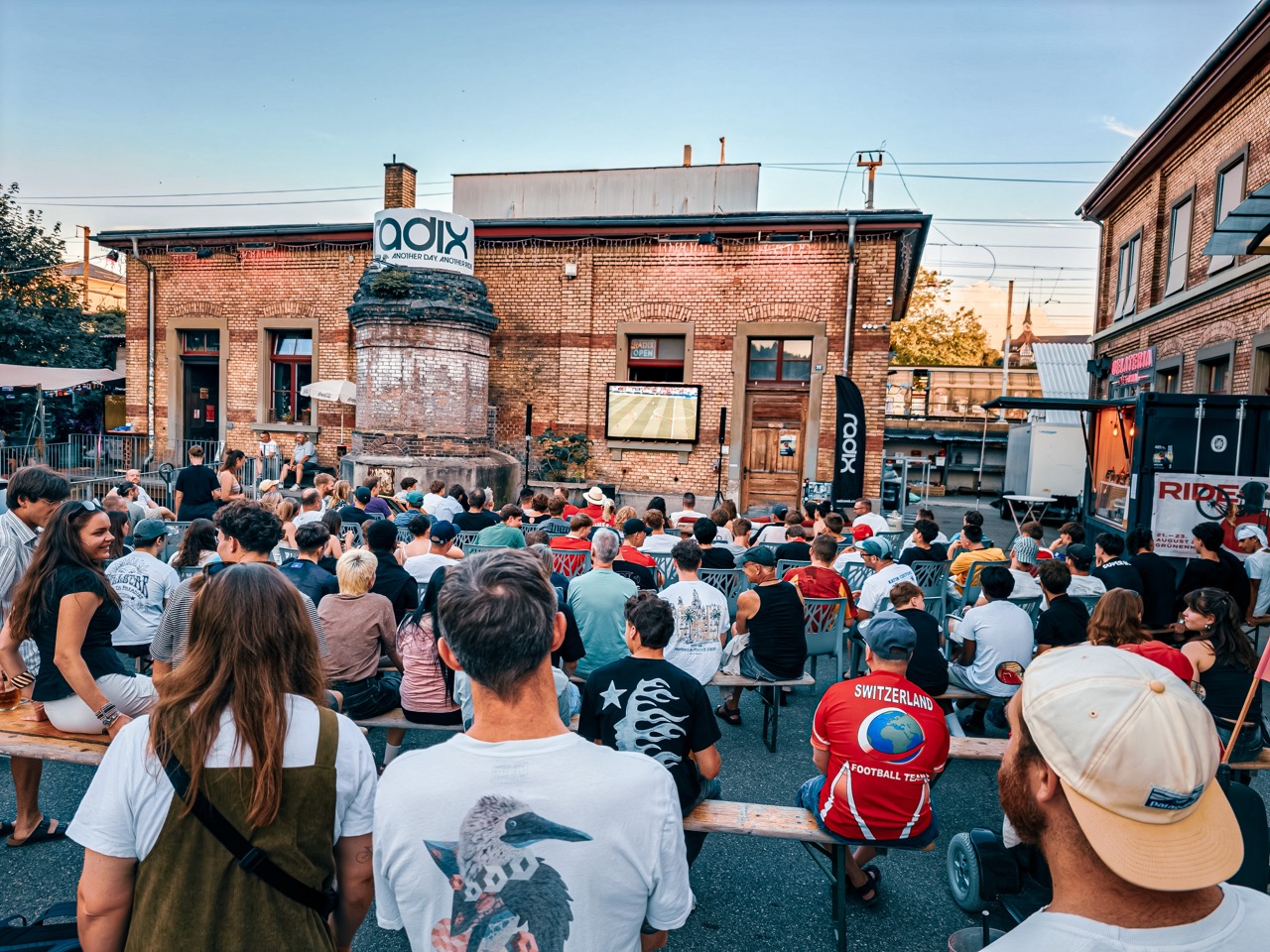 Gro (IMG20260618210440) Open-Air, Outdoor-Veranstaltung, Menschenmenge, Backsteingebäude, Projektionsbildschirm