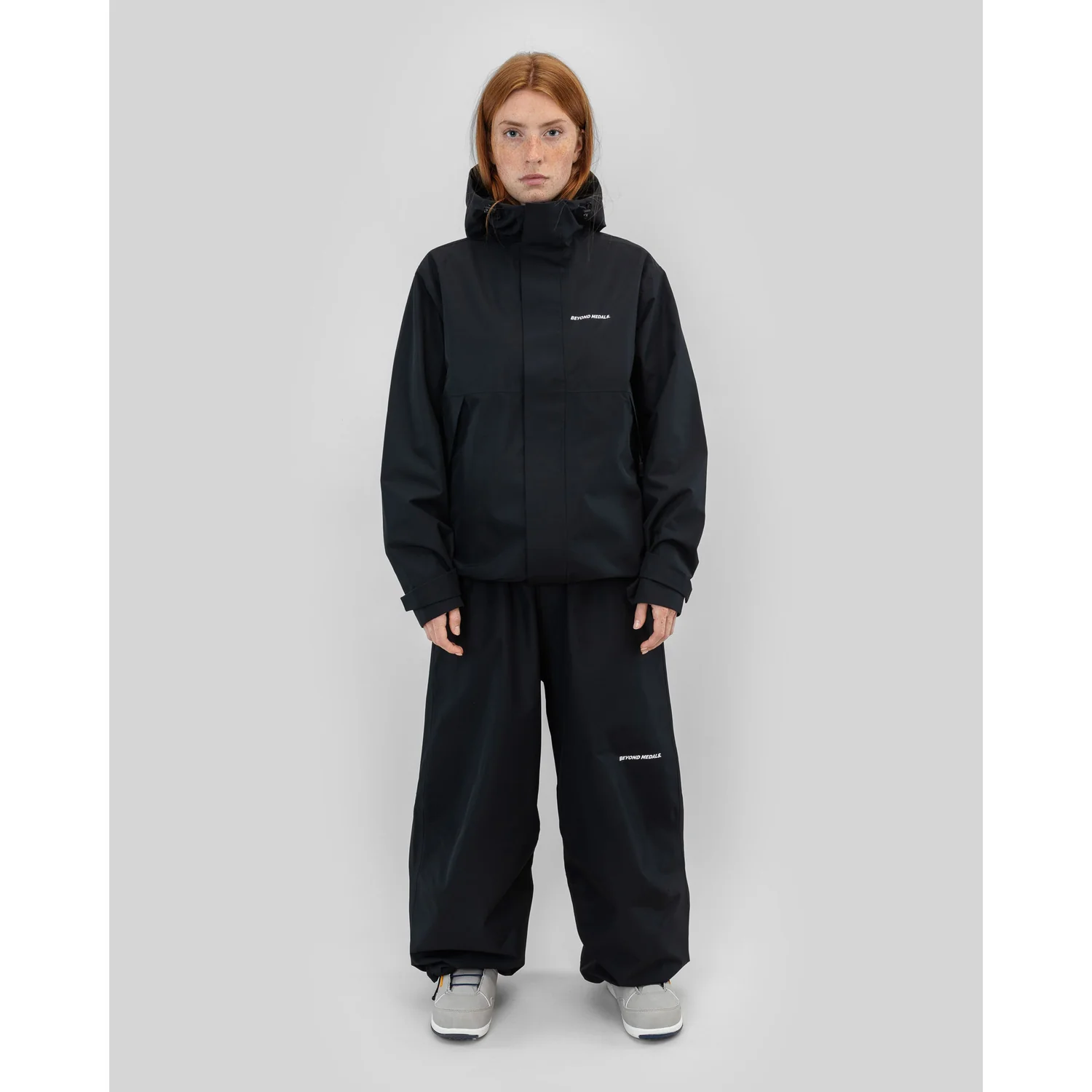 Veste noire, capuche, coupe-vent, pantalon noir, coupe ample