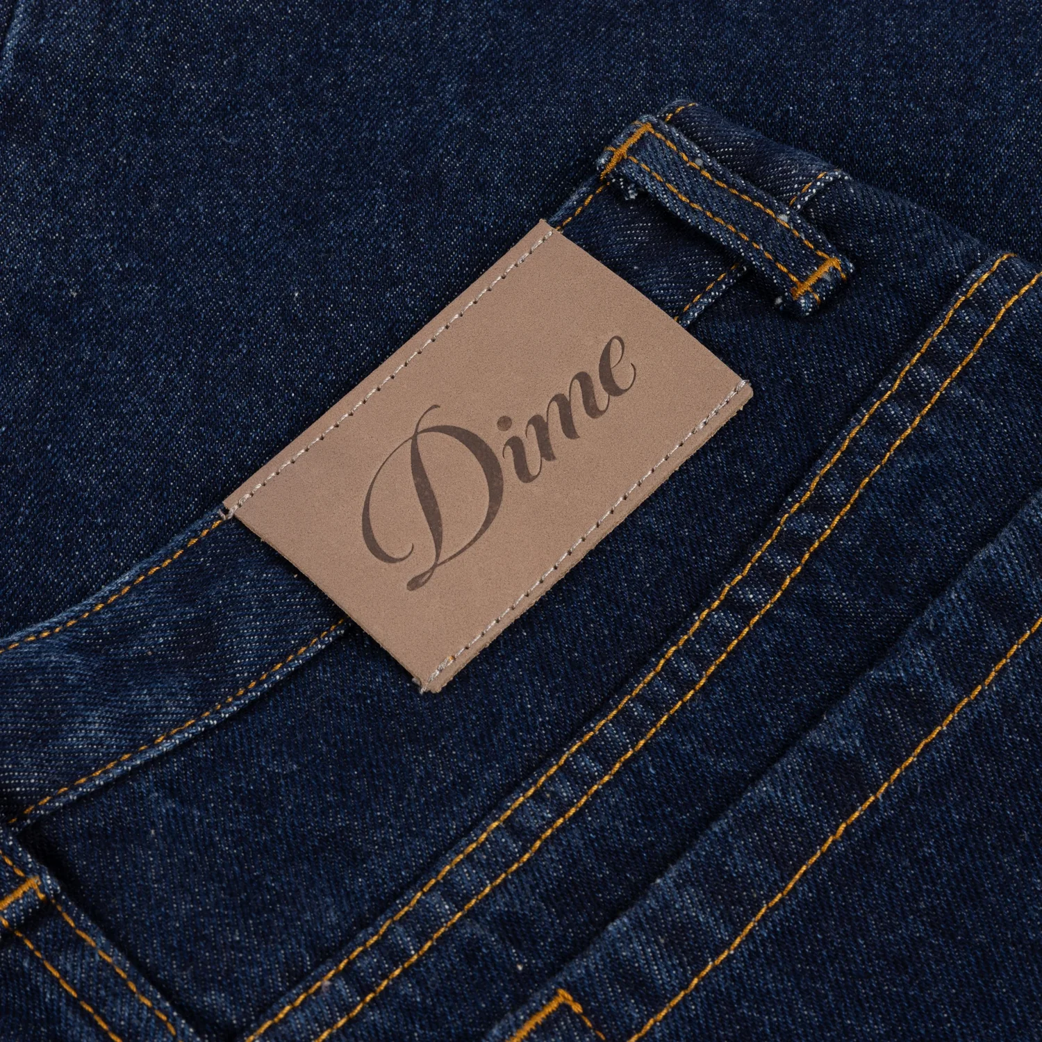 Jean, denim bleu foncé, patch en cuir, coutures contrastées, passants de ceinture