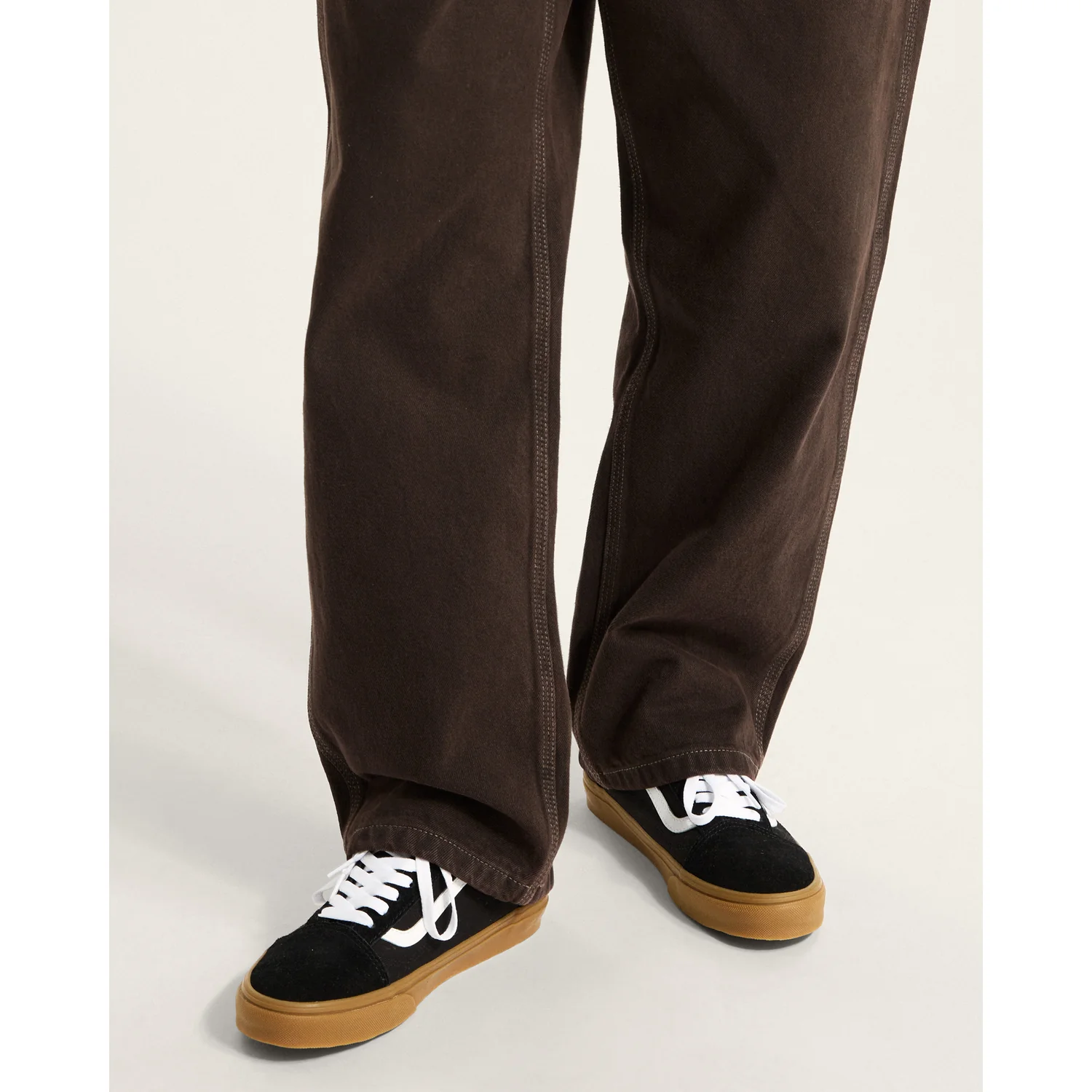 Pantalon large, marron foncé, baskets noires, aspect daim, semelle en caoutchouc