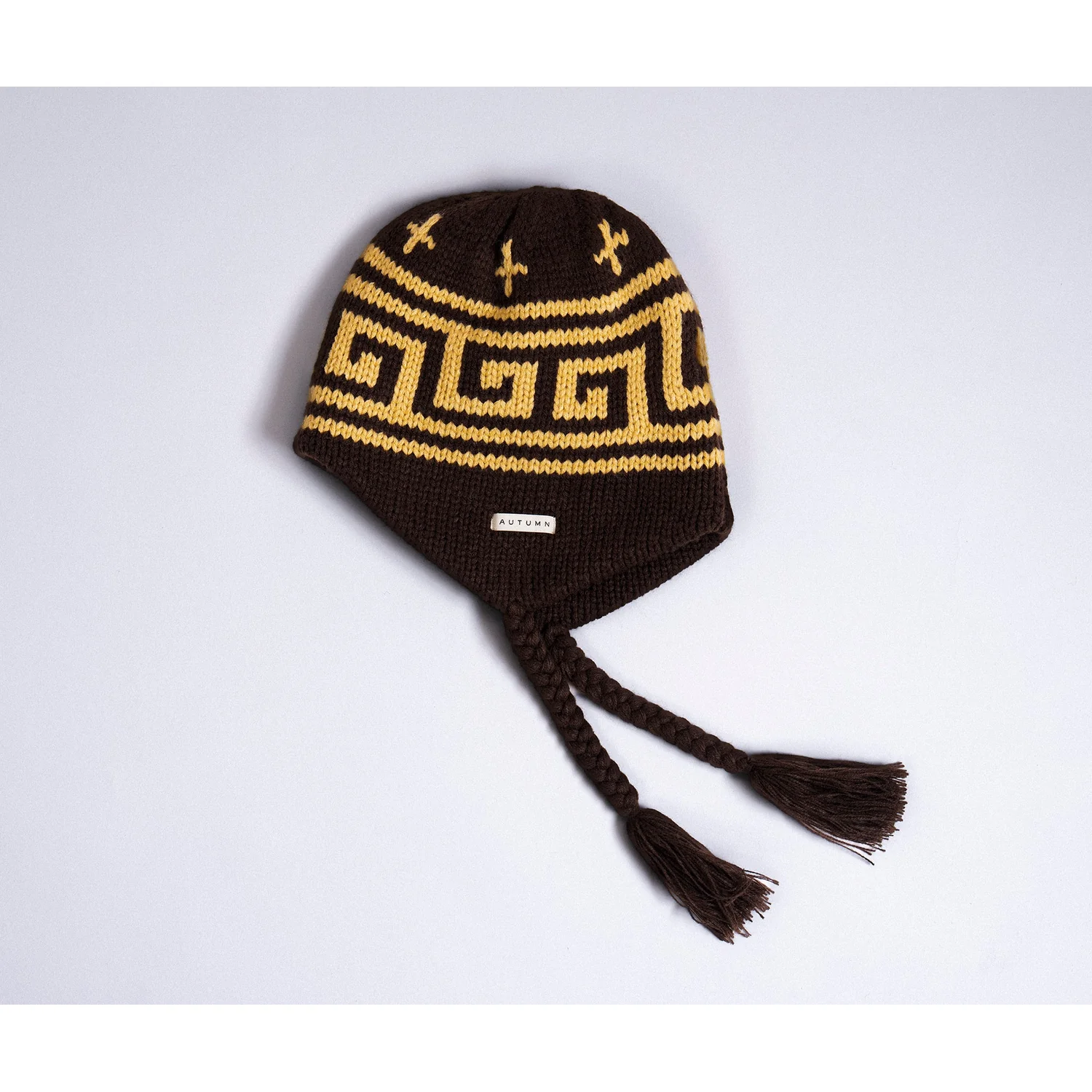 Bonnet en tricot, marron foncé, motif jaune, oreillettes, torsades avec pompons