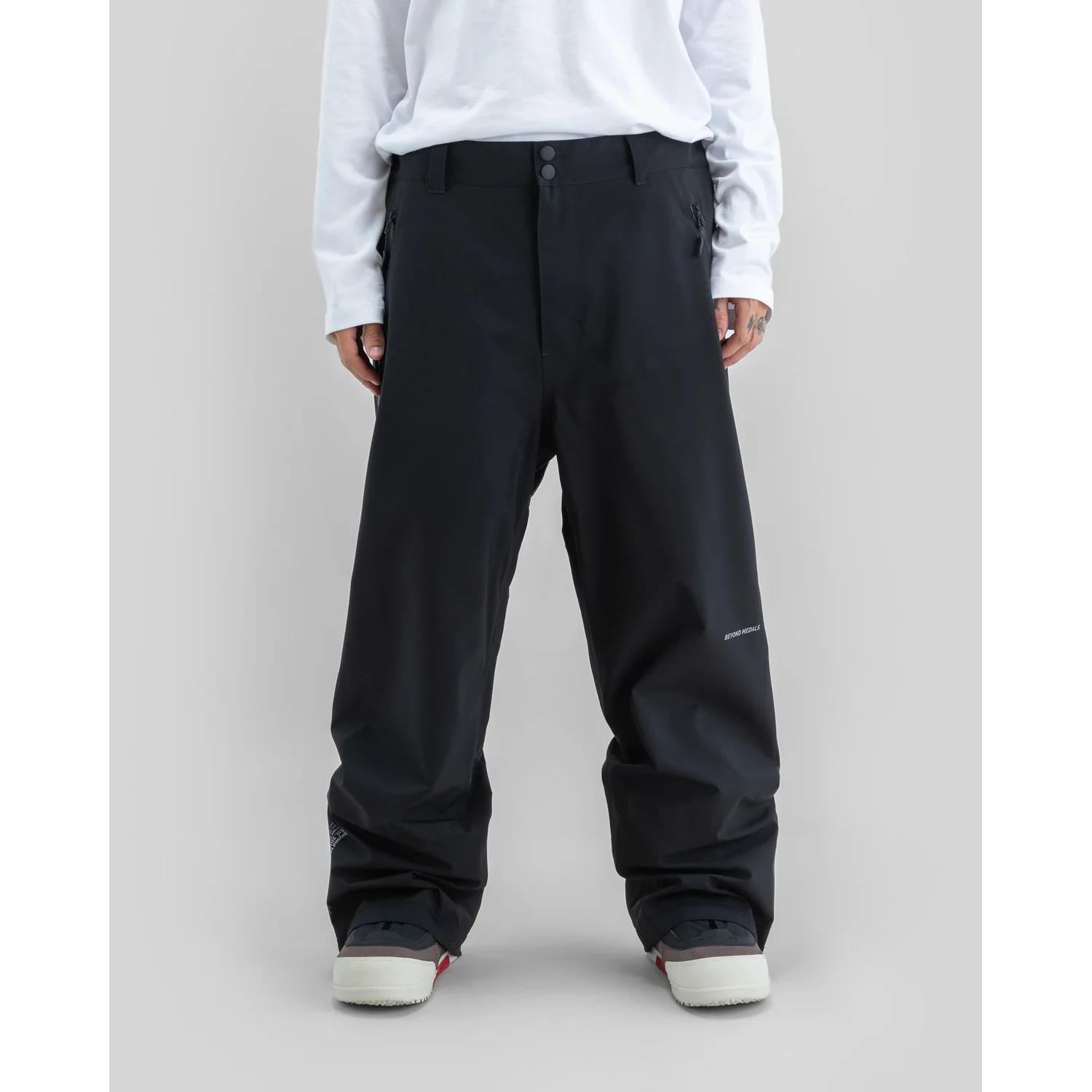 Pantalon de neige, noir, coupe large, poches latérales zippées, fermeture à double bouton