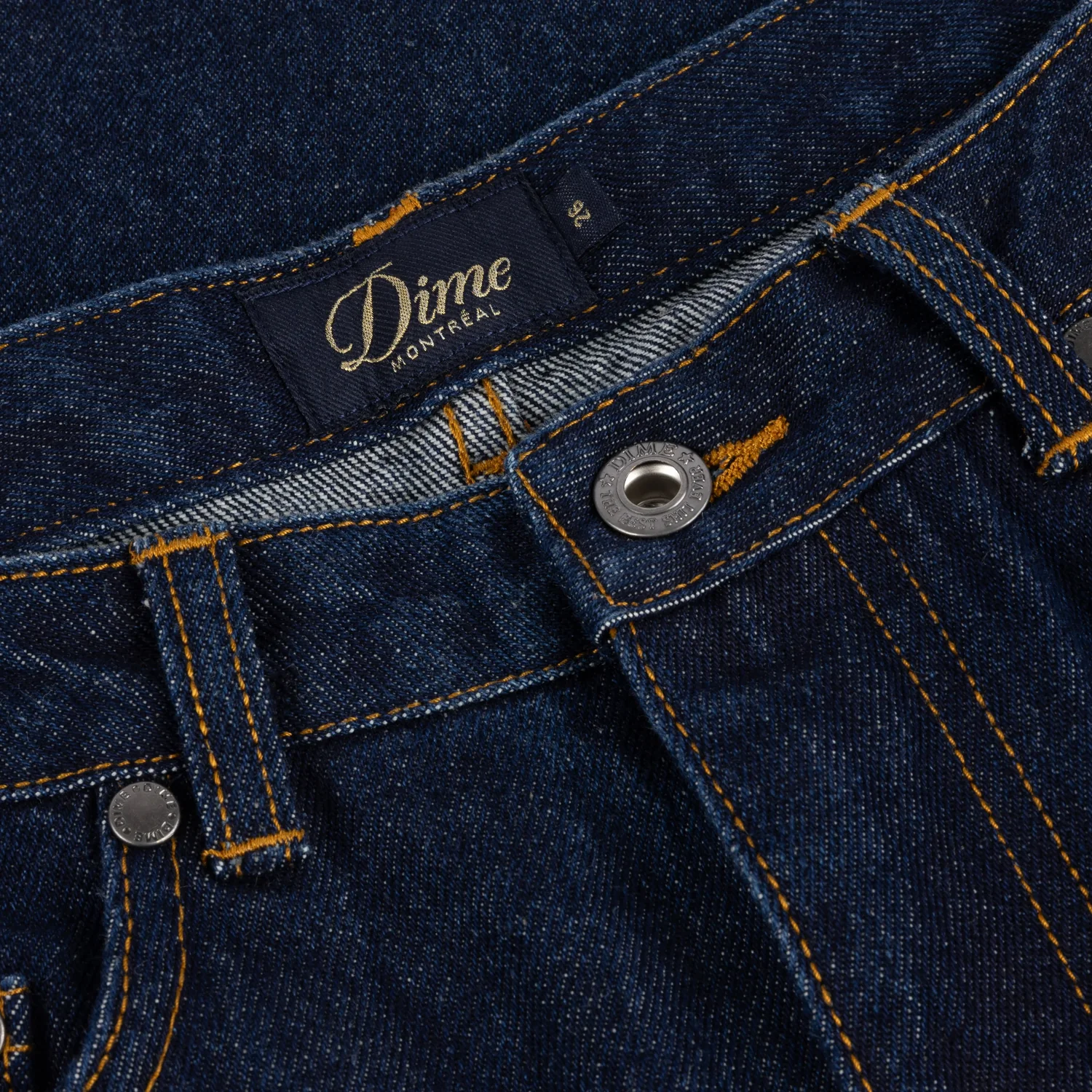 Jeans, denim bleu foncé, coutures contrastées, boutons métalliques