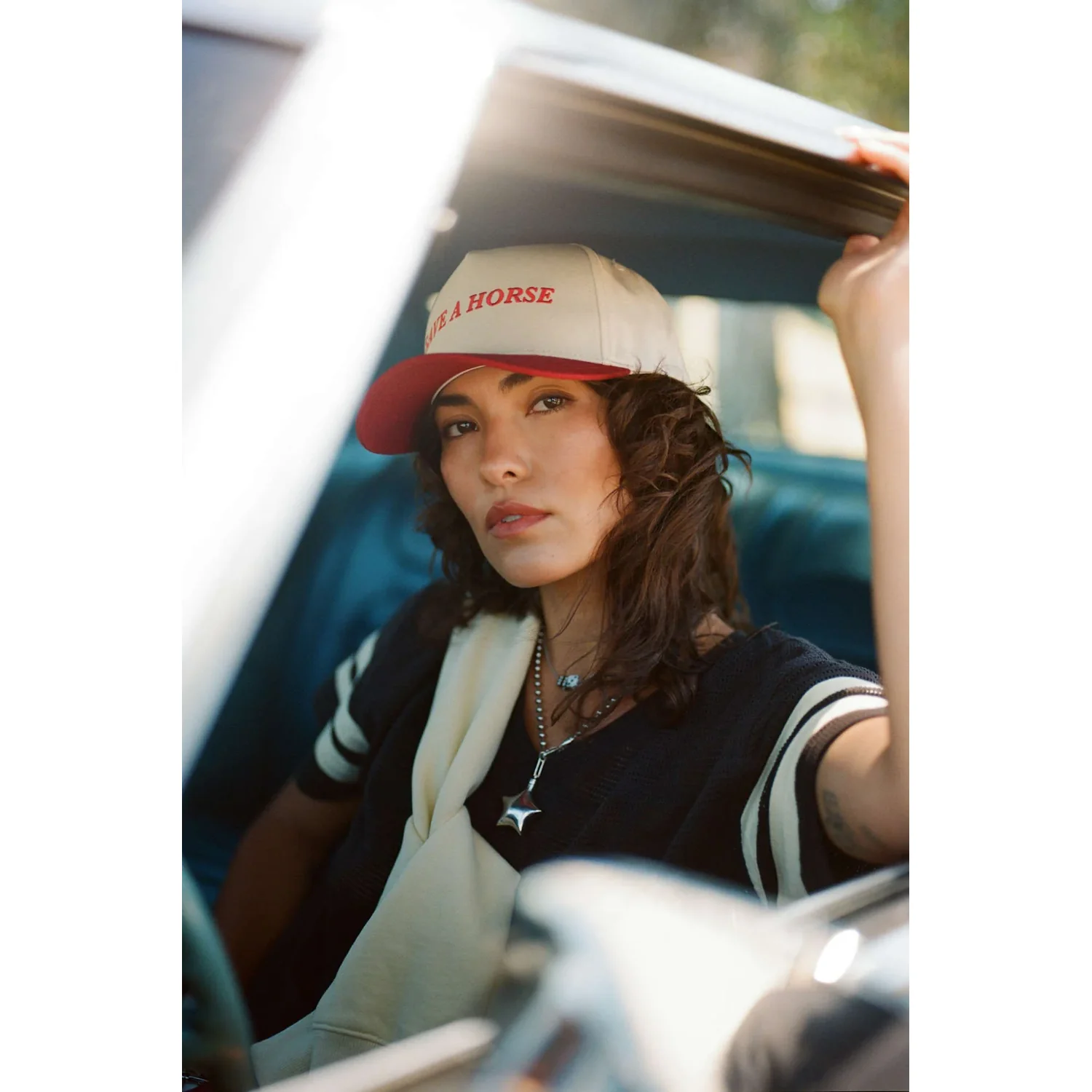 Casquette de camionneur, casquette beige et rouge, visière courbée, t-shirt noir, manches rayées