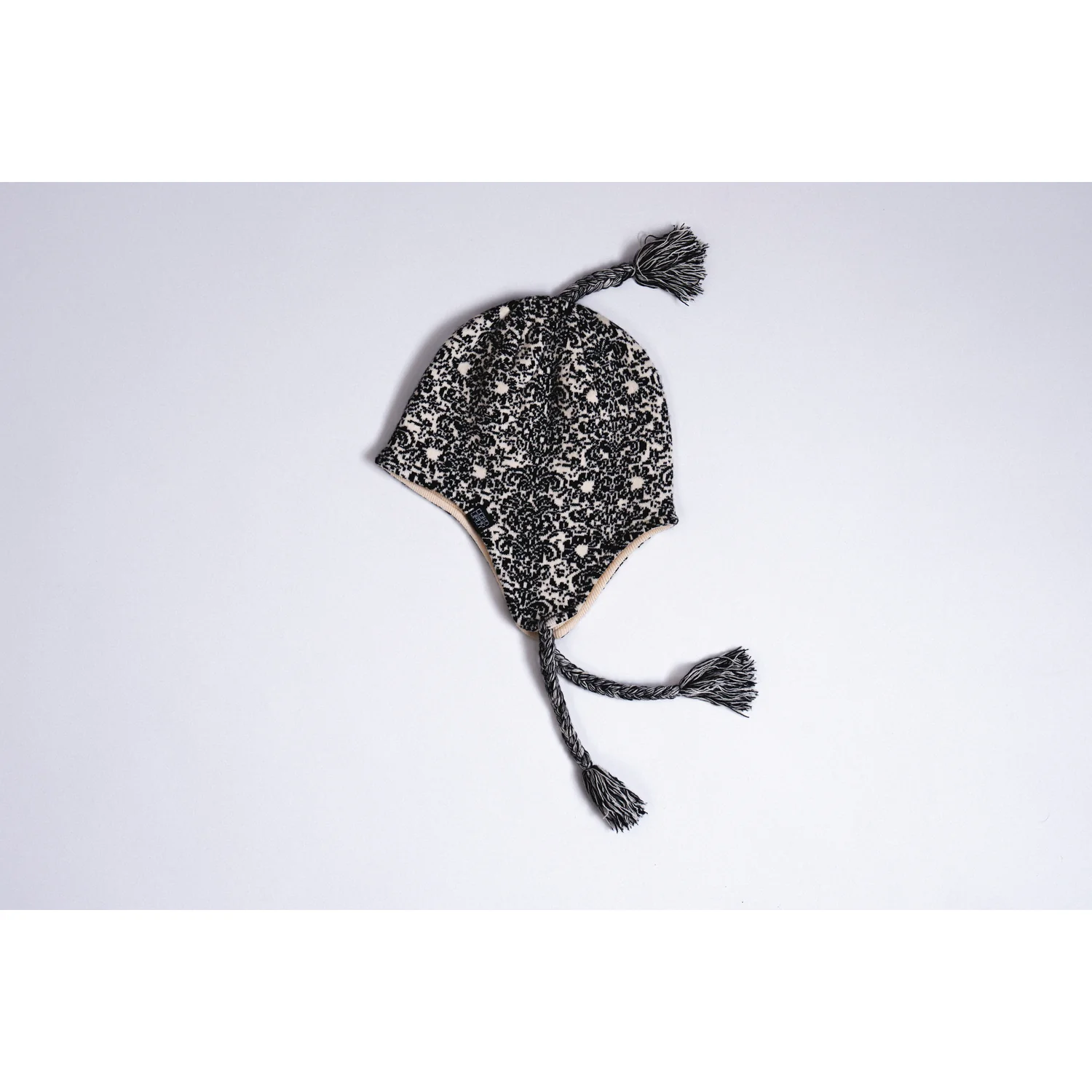 Doily Ear Flap Strickmütze, Ohrenklappen, Schwarz-weiß, Ornamentmuster, Quasten