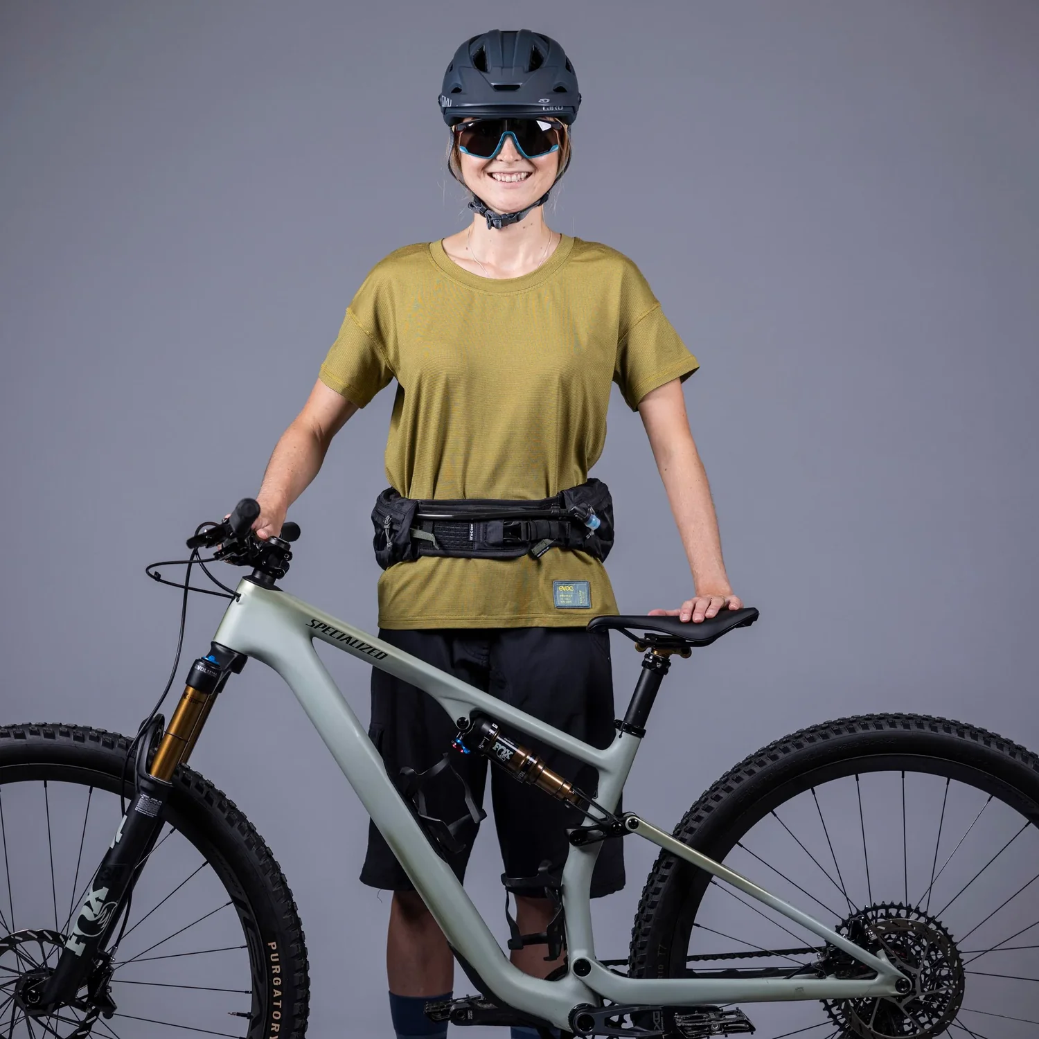 VTT, suspension intégrale, cadre gris, pneus à crampons, casque de vélo